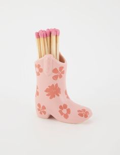 a pair of pink boots with flowers on them and toothpicks sticking out of the boot