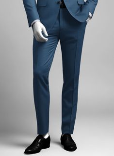 Bring some classic dignity, sophisticated style and warm touch to your work week wardrobe with our Napolean Casa Blue Wool suit. Crafted from wool blend, a long been piece with remarkable comfort and feel which complements the incredible versatility offered by its blue hue. Wear it with a matching waistcoat, a crisp white shirt, dotted light blue tie and brown dress shoes.  Look Includes   Napolean Casa Blue Wool Fabric  Two Button Jacket Style  Notch Lapel  Horn Royal Black Buttons  Single Vent  Three Cuff Buttons  Two Welted Back Pockets on Trousers    Click 'Customize Now' to modify the look if needed.   Lining: Viscose, Dry Clean, Pants can be lightly washed. Tailored Blue Wool Suit, Blue Wool Suits For Workwear, Blue Wool Suits For Work, Formal Blue Wool Bottoms, Elegant Blue Wool Bottoms, Tailored Blue Suits For Office Wear, Blue Wool Suits For Formal Occasions, Formal Slim Fit Blue Dress Pants, Formal Blue Wool Suits