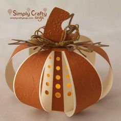 an origami pumpkin with ribbon tied to it's side and the word simply crafty on top