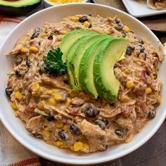 a white bowl filled with guacamole, black beans and avocado