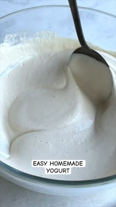 a glass bowl filled with yogurt and a spoon