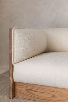 a close up of a white couch with wood frame