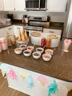 an ice cream sundae bar is set up on the kitchen counter