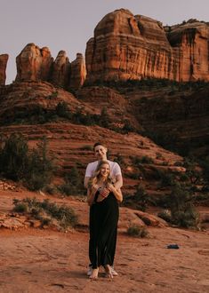 a man and woman are standing in the desert