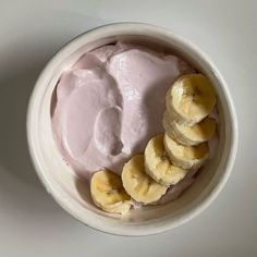 a bowl filled with yogurt and bananas on top of a white countertop