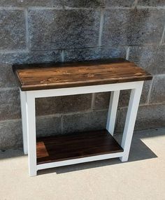 a white and brown table sitting next to a brick wall