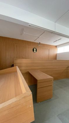 an empty courtroom with wooden benches and no people in the room or on the floor