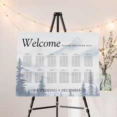 a welcome sign is displayed on an easel in front of a christmas tree and string lights