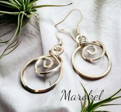 the earrings are made from gold plated metal and have spiral designs on them,