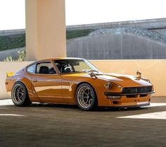 an orange sports car parked in front of a building