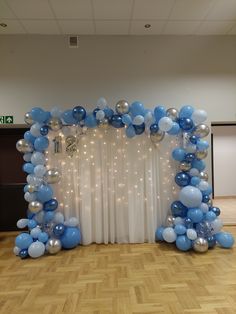 an arch made out of blue and silver balloons