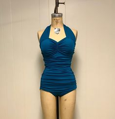 Go ahead and make a splash in the Helen swimsuit, a cute 1950s custom made vintage style bathing suit. The Helen swimsuit has a pinched front with halter straps that tie behind the neck. The side has ruching for a nice flattering effect. It is totally lined and comes with removable bra cups. Go ahead and make a pool side statement in this bathing suit. The Helen swimsuit is made from top quality nylon Lycra swimwear fabric. Boning can be added to the suit for an additional charge. Please message One-piece Swimwear With Fitted Bodice And Lined Body, Fitted Bodice Sleeveless Swimwear For Beach, Fitted Bodice One-piece Swimwear, Fitted One-piece Lined Tankini, Fitted Halter Top For Poolside, Fitted Halter Neck Tankini For Poolside, Retro Halter Neck Fitted Swimwear, Fitted Halter Top For Pool, Retro Fitted Summer Tankini