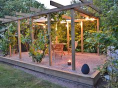 a patio with a table and chairs in the middle of it, surrounded by trees