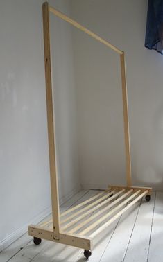 a bed frame sitting on top of a wooden floor next to a wall and window