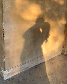 the shadow of a person standing in front of a wall