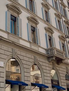 an old building with some blue awnings on the outside and windows above it