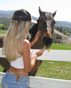 a woman is feeding a horse from her hand