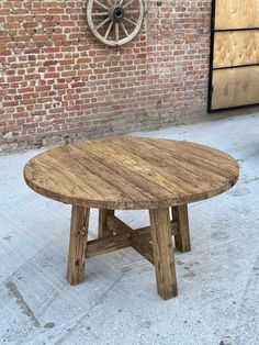 a wooden table sitting in front of a brick wall with wheels on it's side