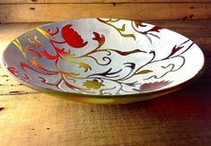 a white and red bowl sitting on top of a wooden table