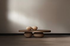 two eggs are sitting on top of a wooden table in front of a gray wall