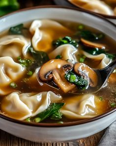 a close up of a bowl of soup with broccoli and dumplings in it