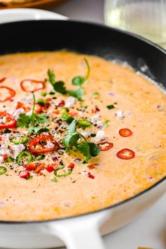 there is a bowl of soup with tomatoes and herbs in it