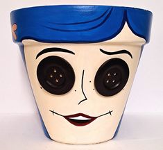 a ceramic planter with a face painted on it