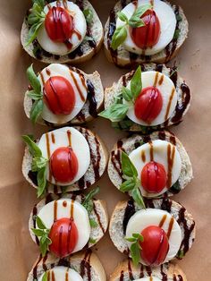 small sandwiches with tomatoes, cheese and sauce on them are arranged in a box to look like they're ready to be eaten