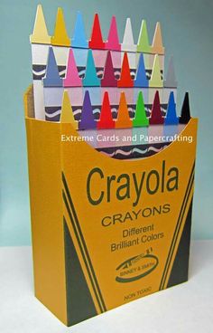 crayons are stacked in a box on a white counter top, with the words crayons written below them