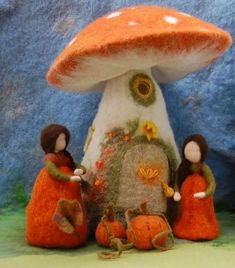 three dolls are standing in front of a mushroom