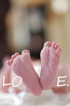 a baby's feet with the word love written in white on top of it