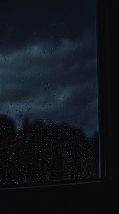 a window with rain drops on it at night