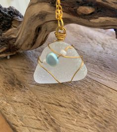 Beautiful handmade pendant.  Frosted white sea glass wrapped in gold and threaded with a baby blue freshwater pearl and 2 tiny white beads.  Gorgeous! Sea glass collected from England's east coast. Wear this beach treasure wherever you go!   It measures 20 x 30 mm.  Two choices of chain lengths. The pearl is for purity and simplicity.  A gift from nature.  Birthstone Gemini. Only one unique design. Makes an ideal gift for that person who likes something different.  Beautifully gift wrapped with White Sea Glass, Gold Wrap, Sea Glass Pendant, White Sea, Wedding Jewellery Necklace, Pendant Gold, Handmade Pendant, White Beads, Handmade Pendants