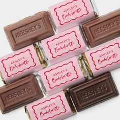 six hershey's chocolate bars are lined up on a white surface with pink and red labels