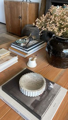 a table topped with books and a vase filled with flowers sitting on top of it