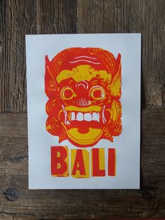 a red and yellow card with an image of a demon on it's face