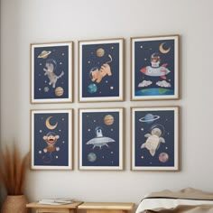 four framed pictures hang on the wall above a bed in a child's bedroom