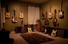 a room with guitars hanging on the wall and rug in front of it that is carpeted