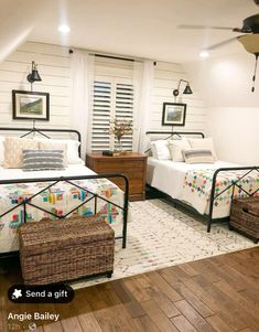 two beds in a room with white walls and wooden floors, one has a basket on the floor