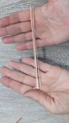 a person holding out their hand with some thin metal bars on it