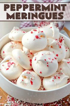 a bowl filled with white and red sprinkles next to a glass of milk