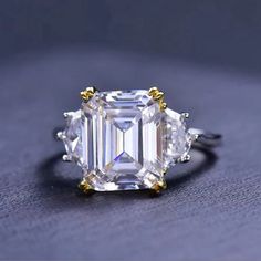 an emerald cut diamond ring on a table