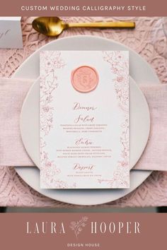 a table setting with pink napkins and white plates, gold utensils and silverware