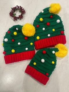 two green and red knitted hats with pom poms