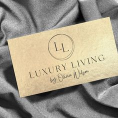 a business card sitting on top of a gray cloth covered in silver and black fabric