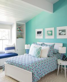 a bed room with a neatly made bed and pictures on the wall