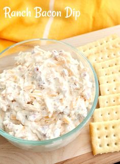 a bowl of ranch bacon dip next to crackers