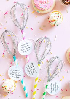 cupcakes, donuts and candy sticks on a pink background with confetti