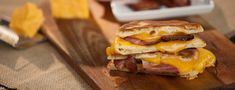 a bacon and cheese sandwich on a cutting board