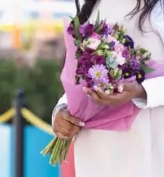 a woman holding a bouquet of flowers in her hands